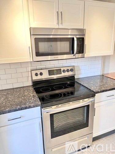 A kitchen with a stove, oven, and microwave.