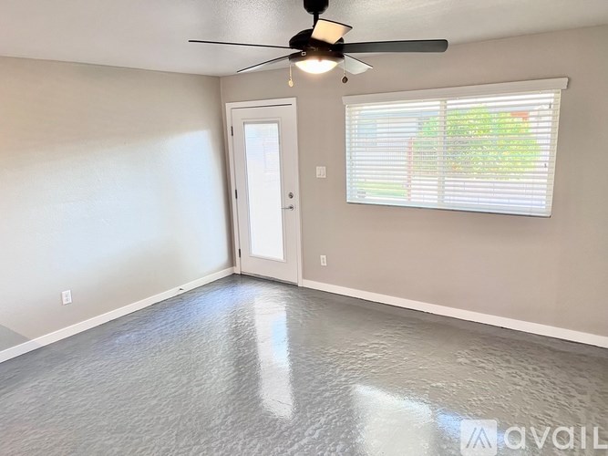 A room with a ceiling fan and a door leading to another room.