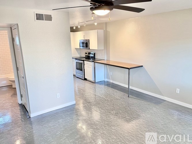 A kitchen with a white wall and a ceiling fan.