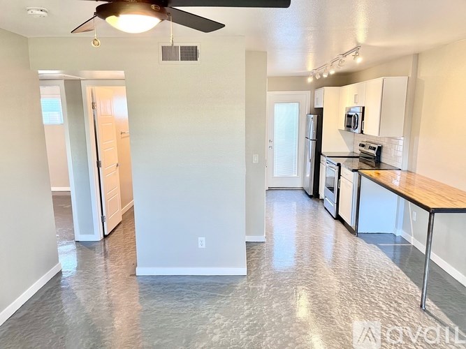 A kitchen with a refrigerator, microwave, and oven.