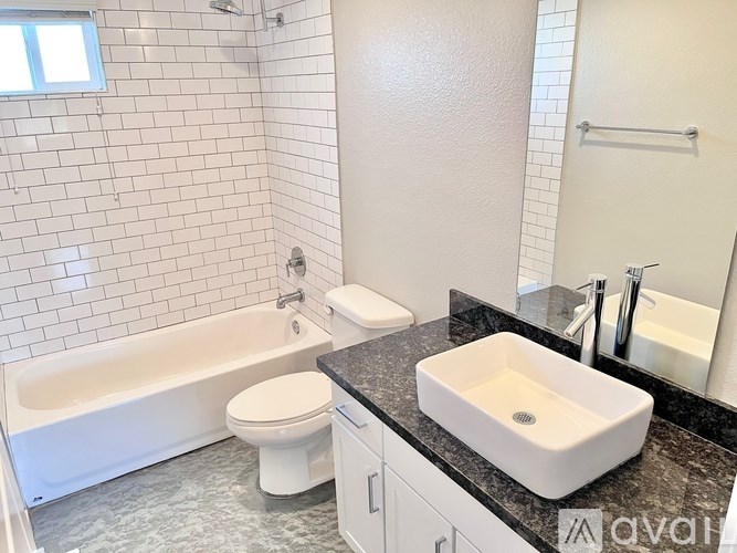 A white toilet sits next to a white sink in a bathroom.