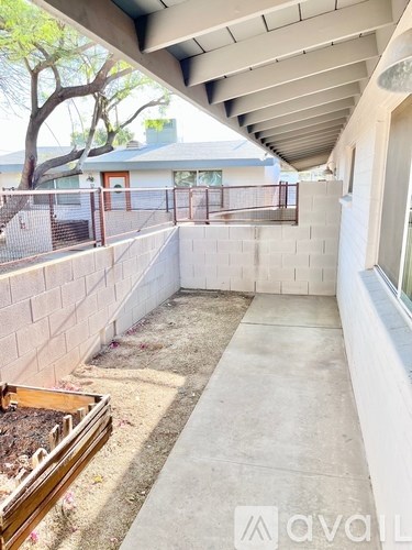 A patio area with a concrete floor and a wall on one side.
