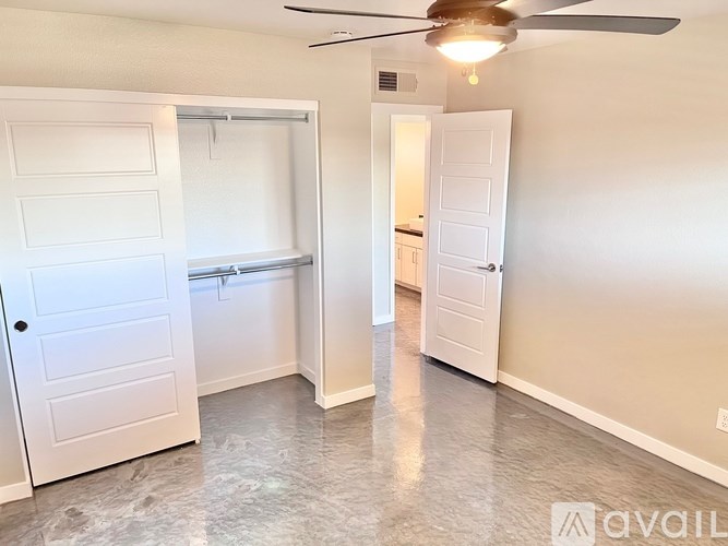 A room with a ceiling fan and two white doors.