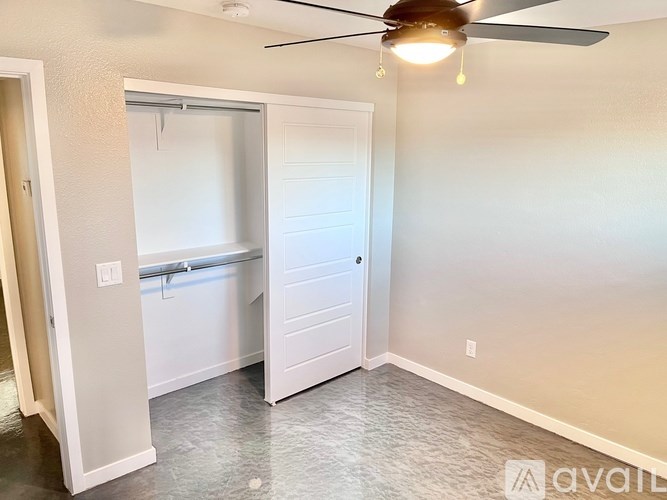 A room with a ceiling fan and a white door.