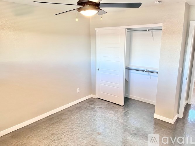 A room with a ceiling fan and a door leading to another room.