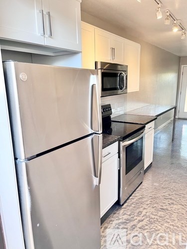 A kitchen with a stainless steel refrigerator and microwave.