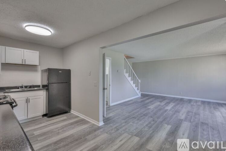 A kitchen with a refrigerator, cabinets, and a stove top oven.
