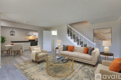 A spacious living room with a staircase leading to the upper floor.