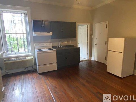 A kitchen with wooden floors and white appliances.