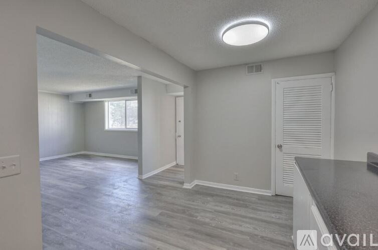 A room with a grey floor and a window with white blinds.