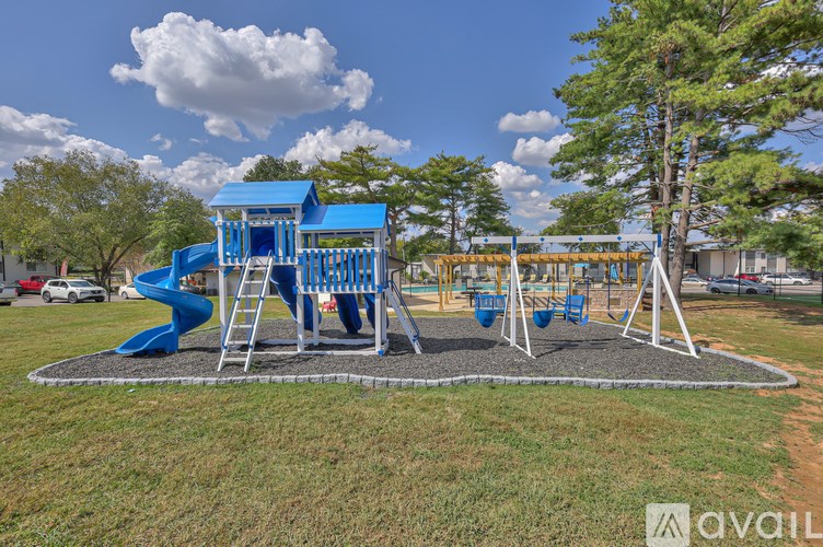 A playground with a blue slide and swings.