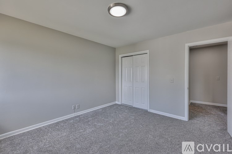 A room with a carpeted floor and a white door.