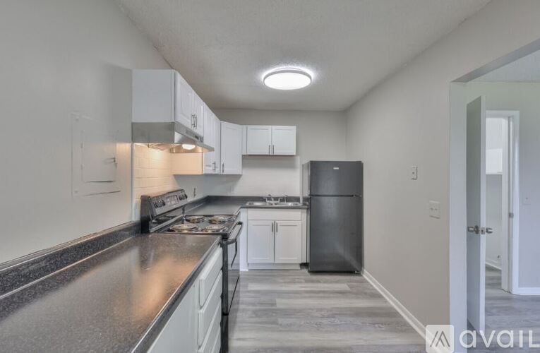A kitchen with a stove top oven and a refrigerator.