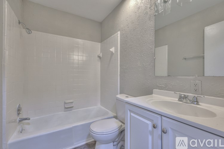 A white bathroom with a tub, toilet, and sink.