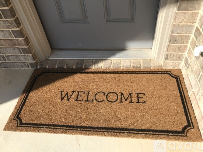 A brown doormat with the word "WELCOME" on it.