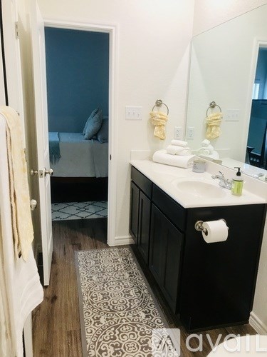 A bathroom with a sink, mirror, and a rug.