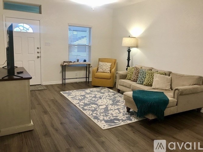 A living room with a couch, chair, and television.