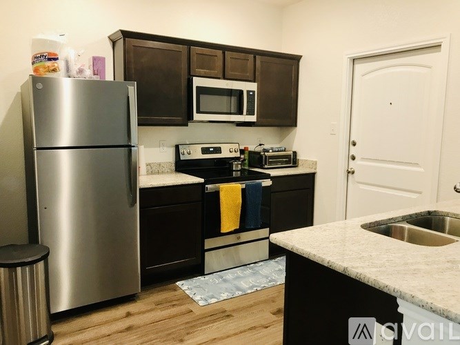 A kitchen with a stainless steel refrigerator, microwave, and oven.