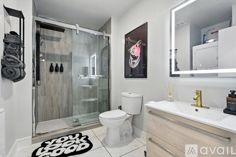 A bathroom with a toilet, sink, and shower.