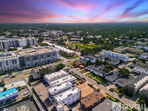 A bird's eye view of a cityscape with buildings, roads, and a swimming pool.