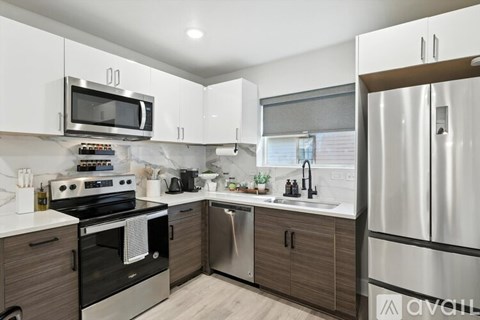 A kitchen with a stove, oven, microwave, and refrigerator.
