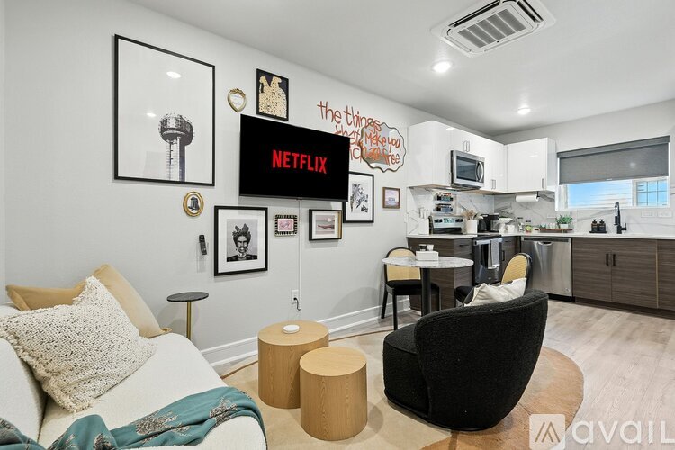 A living room with a white couch and a black chair.
