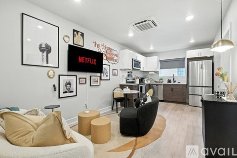 A living room with a couch, chair, and a wall with pictures and a sign.