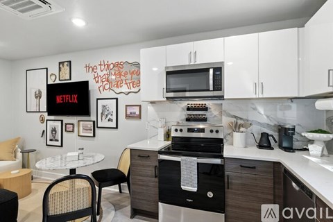 A kitchen with a white countertop and a black chair.