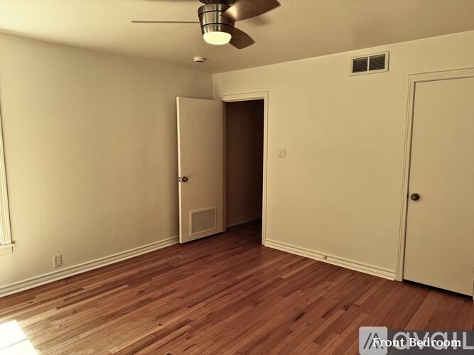 A room with a ceiling fan and two doors.