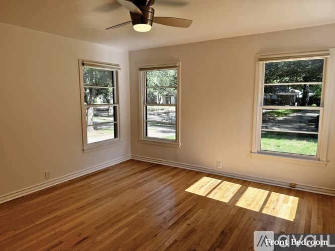 A room with wooden floors and a ceiling fan.