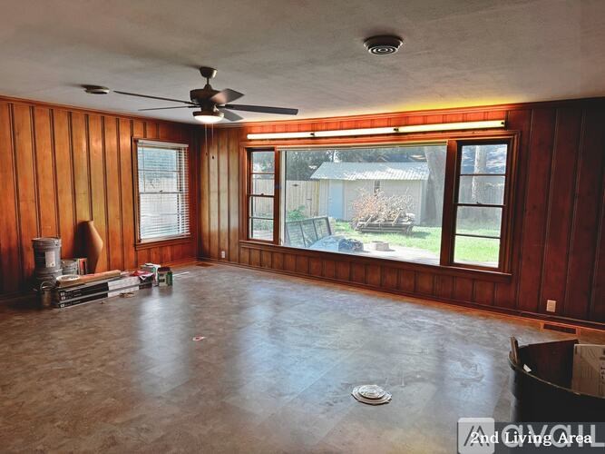A room with wooden walls and a ceiling fan.