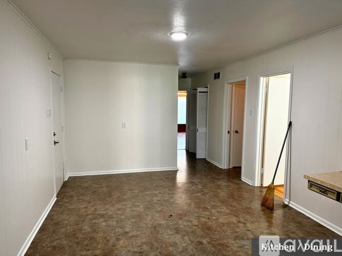 A clean, empty room with a broom in it.