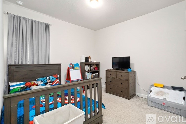 A child's bedroom with a bed, dresser, and a TV.