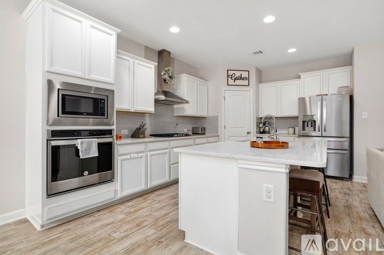 A kitchen with white cabinets and stainless steel appliances.