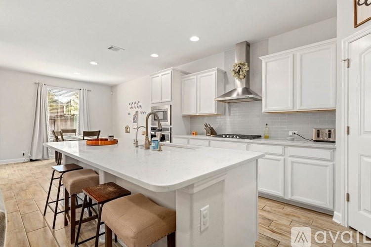 A kitchen with white cabinets and a large island.