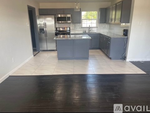 A kitchen with a refrigerator, stove, and sink.