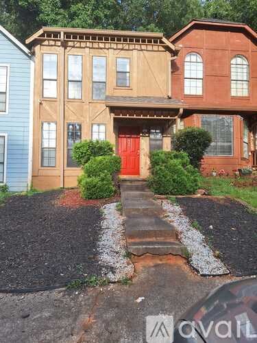 A house with a red door and a brown roof.