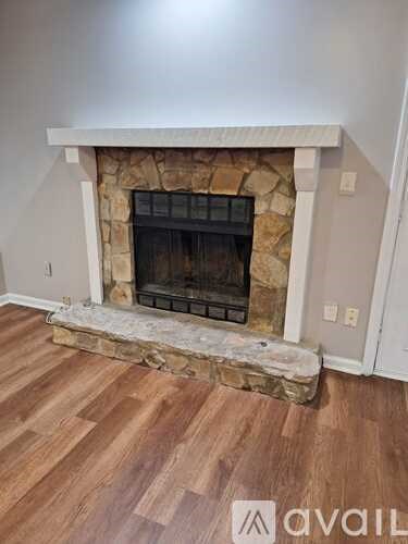 A stone fireplace with a wood burning stove inside.
