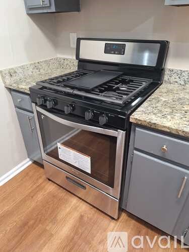 A stainless steel oven with a digital display is installed in a kitchen.
