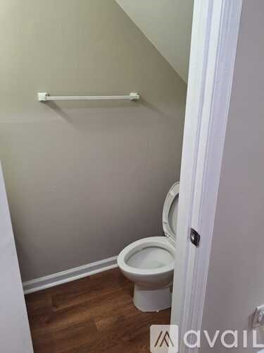 A white toilet in a small bathroom with a white door.