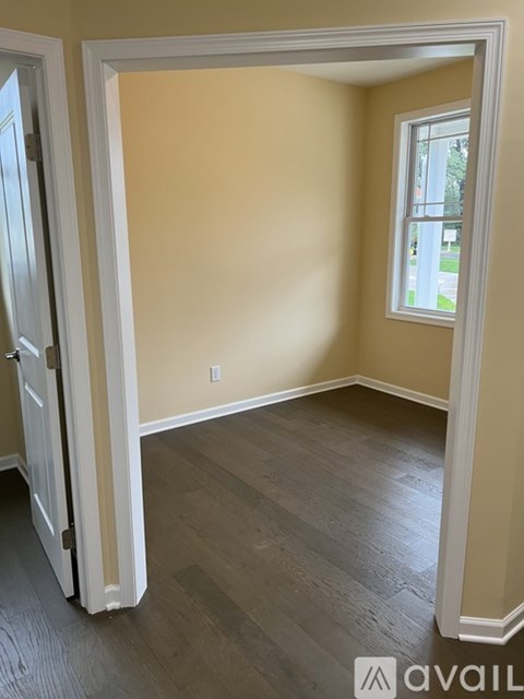 A room with a wooden floor and a window.