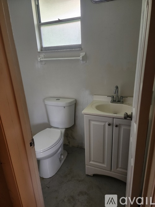A small bathroom with a toilet, sink and window.