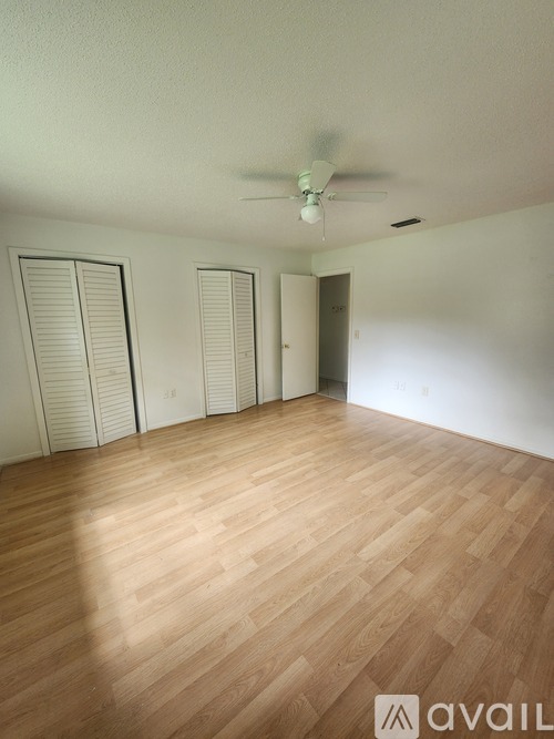 A room with wooden flooring and a ceiling fan.