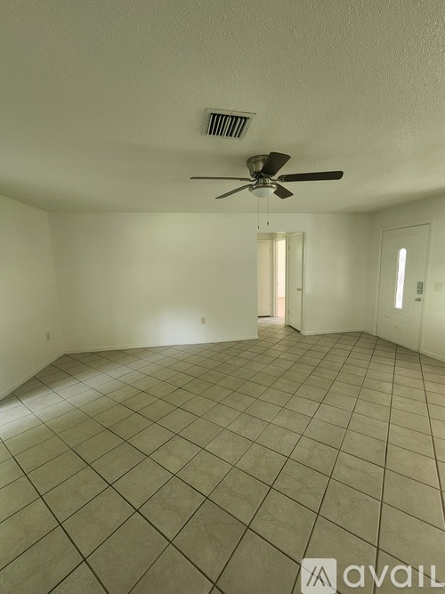 A spacious room with a ceiling fan and tiled flooring.