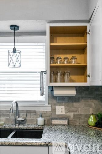 A kitchen with a granite countertop and a sink.