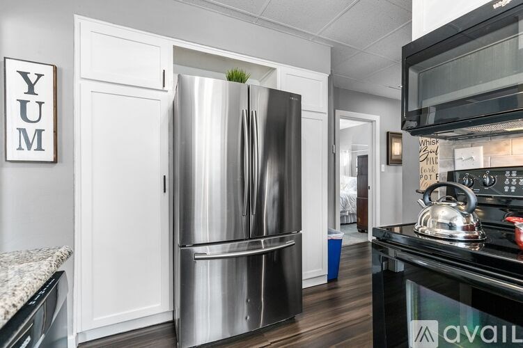 A modern kitchen with a stainless steel refrigerator and a black stove top.
