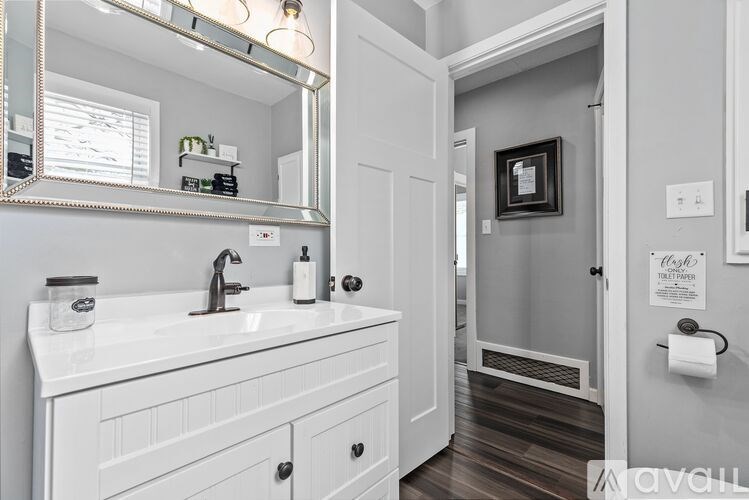 A bathroom with a white sink and a mirror above it.