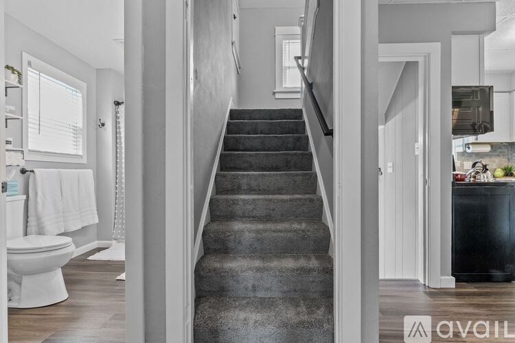 A staircase in a modern home leading to a kitchen.