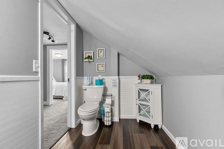 A bathroom with a toilet, sink, and mirror.