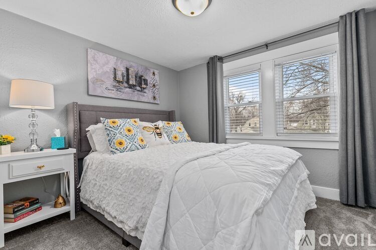 A bedroom with a bed, nightstand, and window.